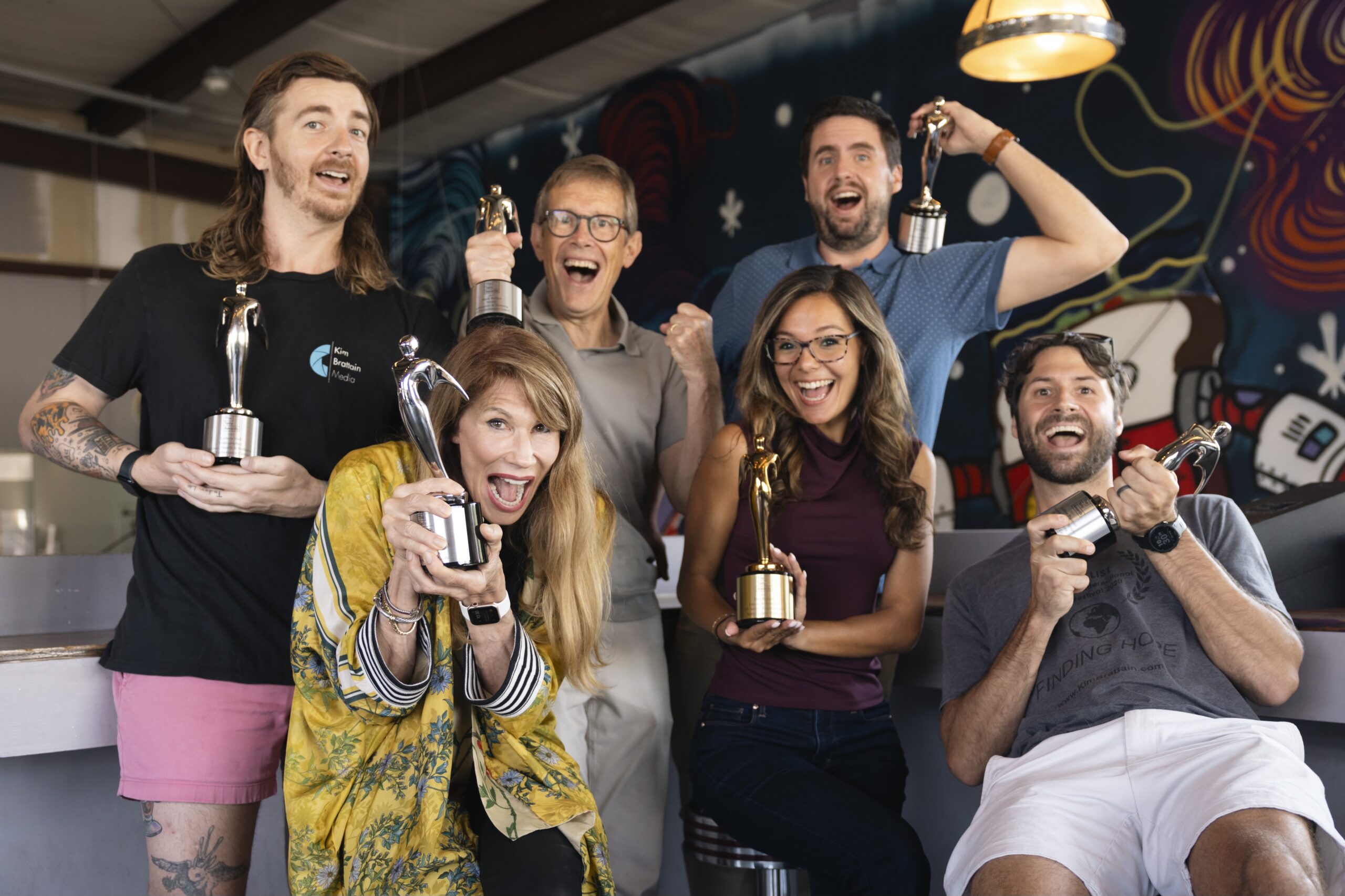 a group of videographers standing next to each other holding up trophies